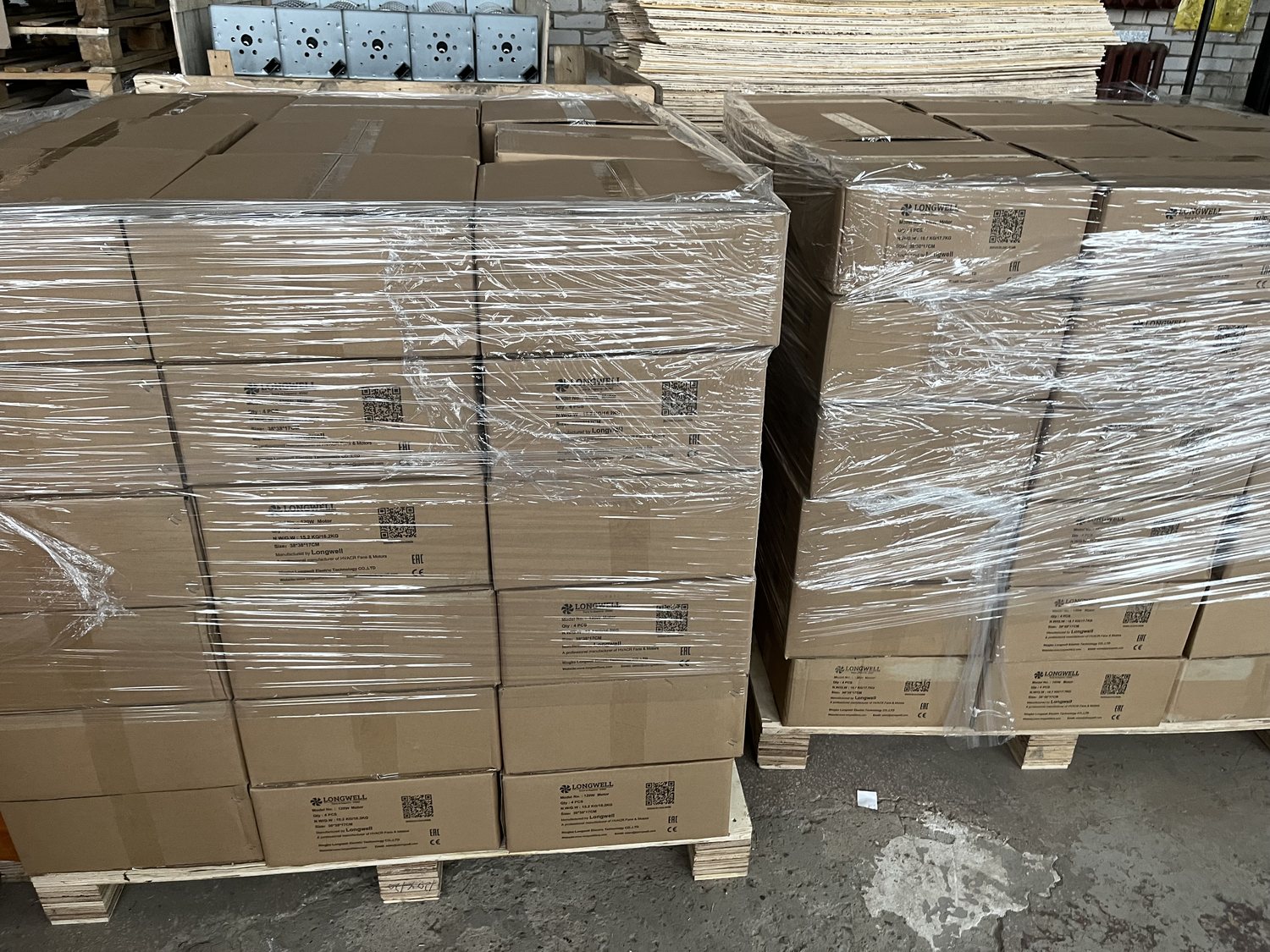 客户仓库中缠膜打托的朗伟电机纸箱,箱体标有 CE 与 EAC